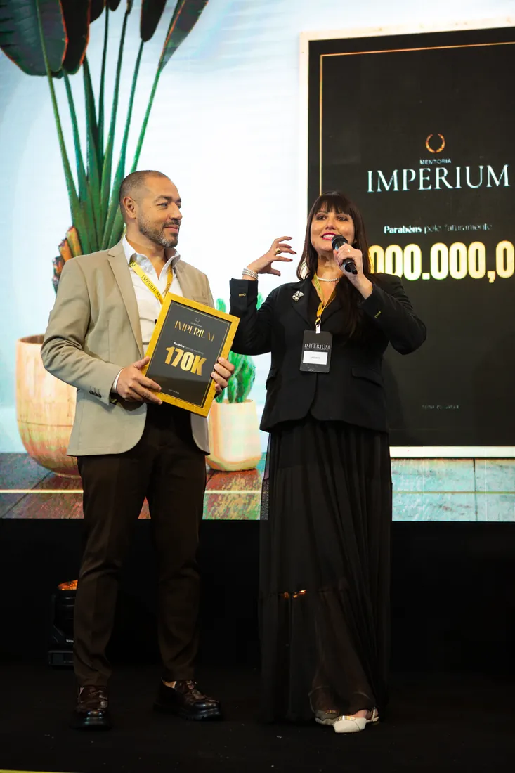 Mentorados com placa de faturamento no palco do Imperium